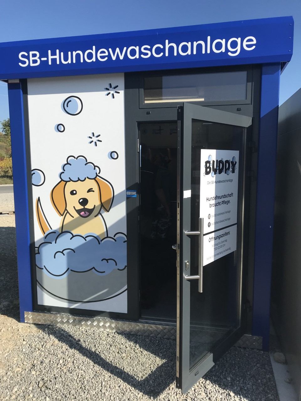 Gebäude der SB-Hundewaschanlage mit blauem Schild